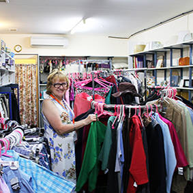 Image of woman volunteer racking clothing inside the Eltham Store