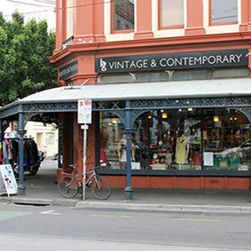 Image of the outside of the Fitzroy shop in Brunswick Street with vintage and contemporary signage prominent on orange building