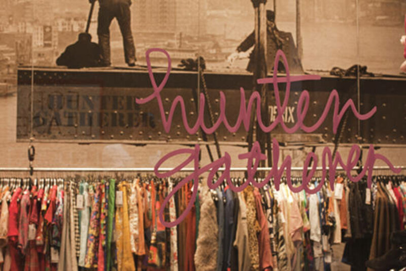 Image of clothing hanging in racks in-store - view from through glass with hunter gatherer logo 
